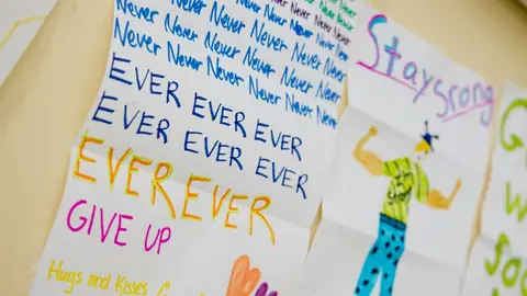 Hand-drawn encouraging notes on a wall with messages to stay strong